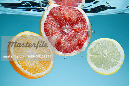 Slices of pink grapefruit, orange and lemon underwater Slices of pink grapefruit, orange and lemon underwater