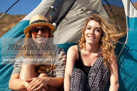 Girlfriends relaxing beside tent
