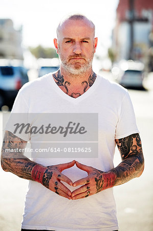 Mature man with tattoos on arms and neck