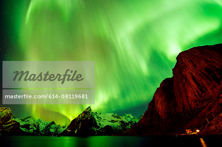 View of green aurora borealis over sea and mountains, Reine, Norway View of green aurora borealis over sea and mountains, Reine, Norway