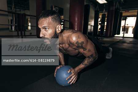 Male boxer doing push up training in gym