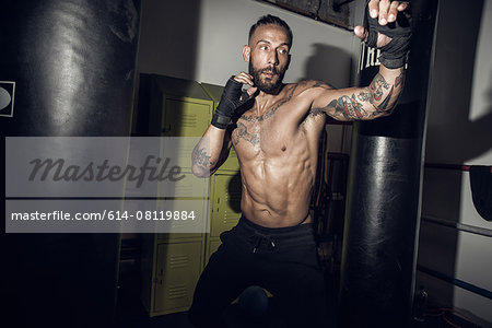 Poised male boxer with bandaged hands in gym