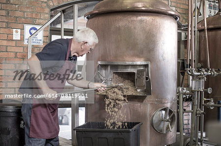 Brewer cleaning a copper kettle in the brewery