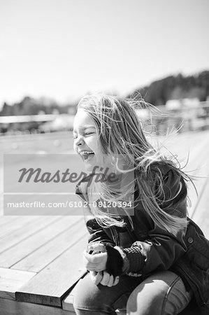 Laughing girl sitting on jetty