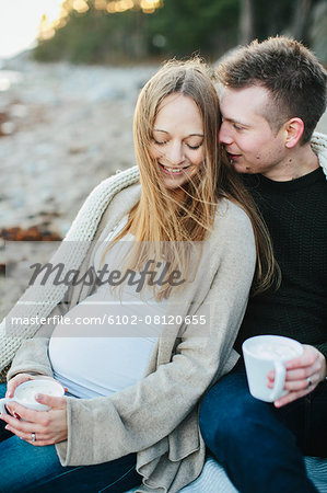 Young couple having drink on beach