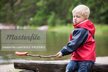 Boy with sausage on stick