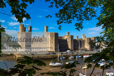 Boats at low tide in front of Caernarfon Castle, Caernarfon, Gwynedd, Wales, United Kingdom