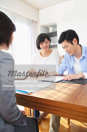 Young Japanese couple consulting with financial planner