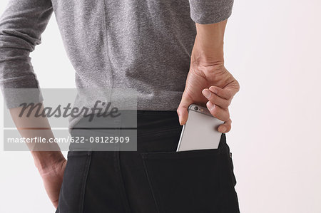 Young man with smartphone in his pocket