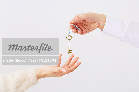 Man and woman hands passing key