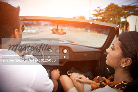 Mid adult couple in convertible car, rear view
