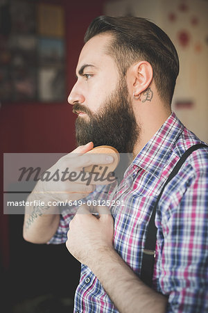 Young bearded man brushing his beard
