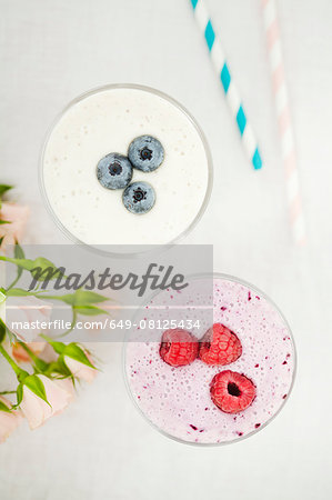 Overhead still life of fresh raspberry and blueberry smoothies