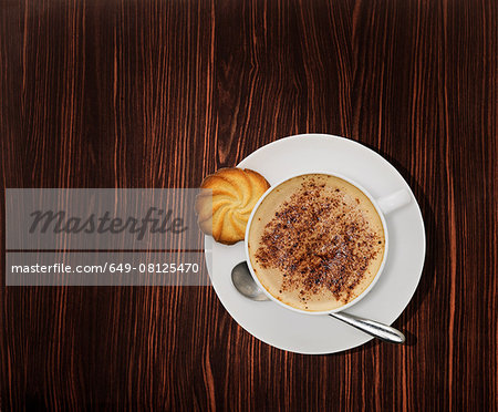 Overhead view of a cappuccino coffee on wooden table