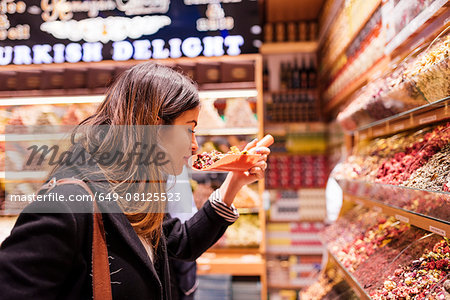 Young woman smelling food in market, Istanbul, Turkey