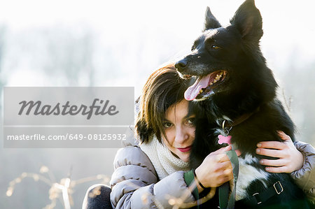 Portrait of mid adult woman hugging her dog