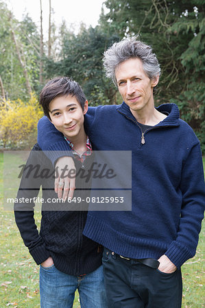 Portrait of mature man and teenage son in garden