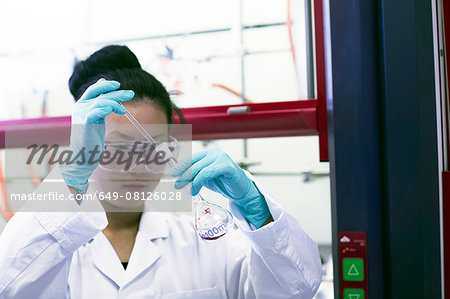 Female scientist pipetting sample in lab
