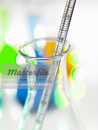 Close up of graduated pipette and laboratory flask