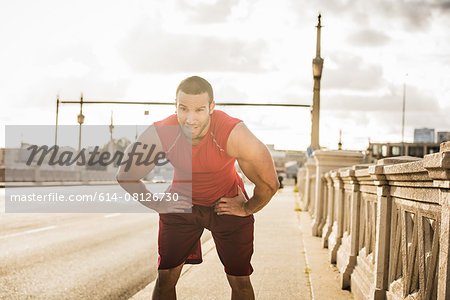 Male runner taking a break on bridge, Los Angeles, California, USA