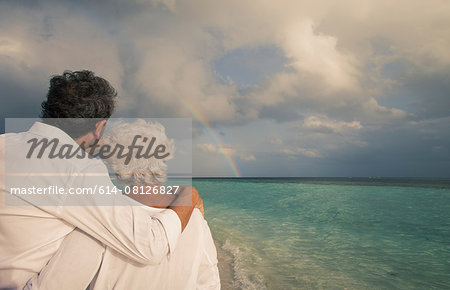 Senior couple looking at rainbow over sea, Maldives