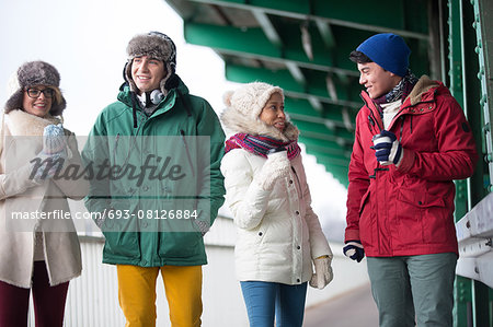 Multiethnic friends in winter wear conversing outdoors