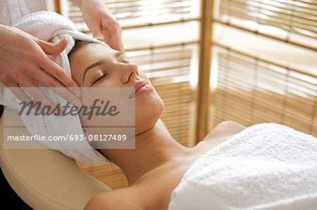 Young woman receiving energy therapy, eyes closed