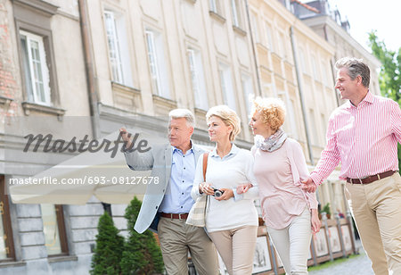 Man showing something to friends while walking in city