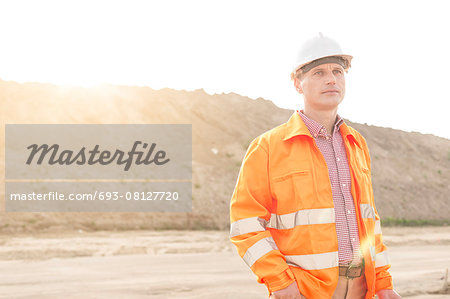 Thoughtful male supervisor looking away at construction site