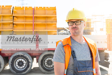 Thoughtful architect standing against truck at construction site