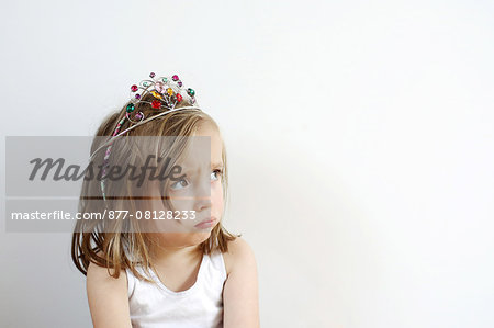 Portrait of a 3 years old girl pouting with a princess crown on the head