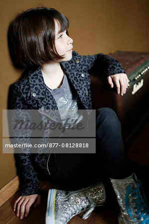 Little girl sitting near a amplifier