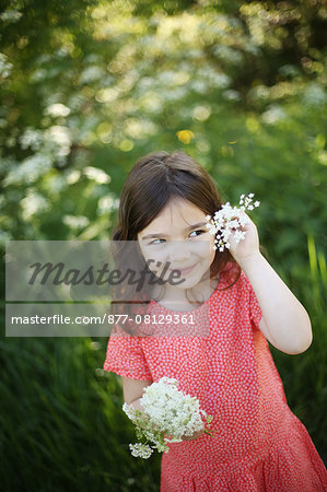 A 5 years old girl with flowers in the countryside