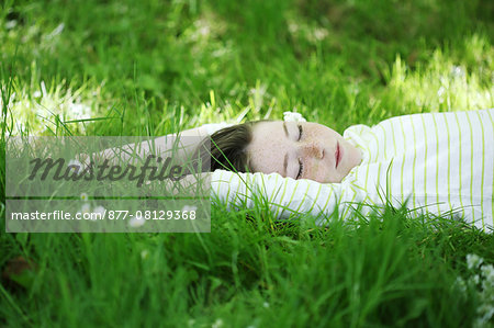 Portrait of a 9 years old girl elongated in the grass