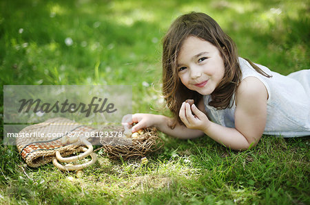 A 5 years old girl eating Easter eggs in the countryside
