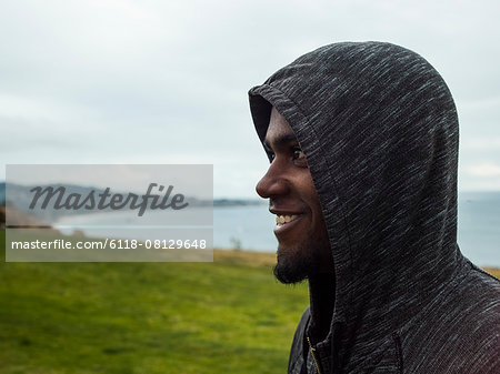 Close up of a smiling young men wearing a hoodie.