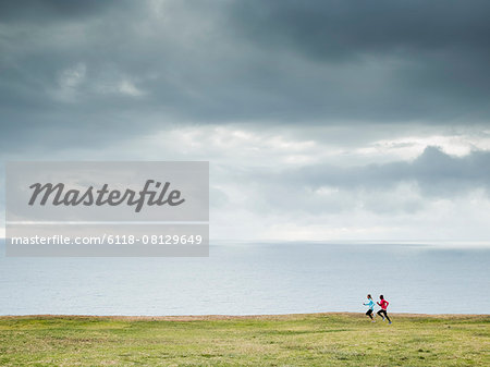Two women jogging along the coast.