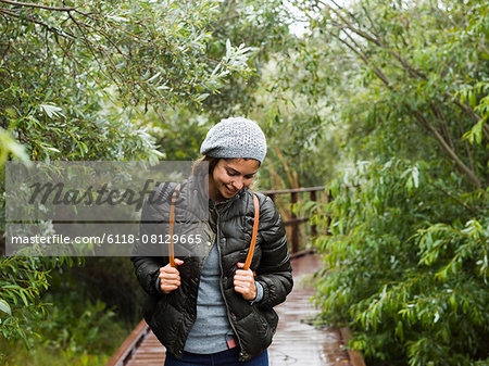 A young woman with beret and rucksack walking on a path.