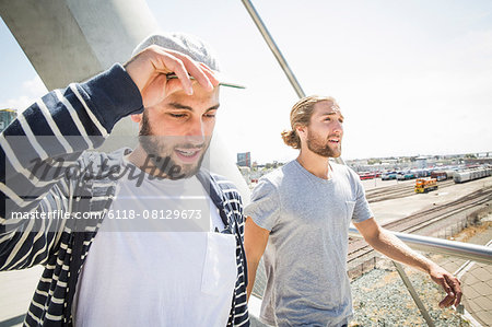 Two young men walking along a bridge.