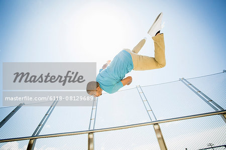 Young man somersaulting on a bridge.
