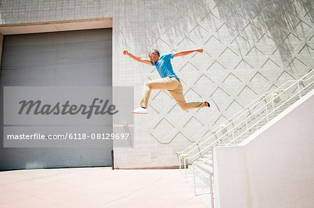 Young man jumping in the air down a stairway.