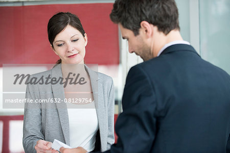 Hotel reception staff providing bill to guest