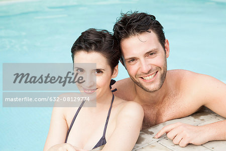Couple relaxing together in pool, portrait