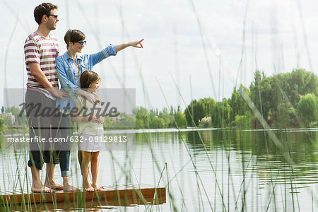 Family standing on dock looking into distance