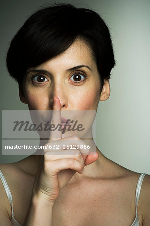 Mid-adult woman making shush gesture