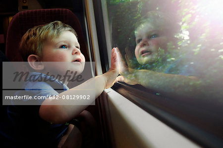 Baby boy gazing out train window in awe
