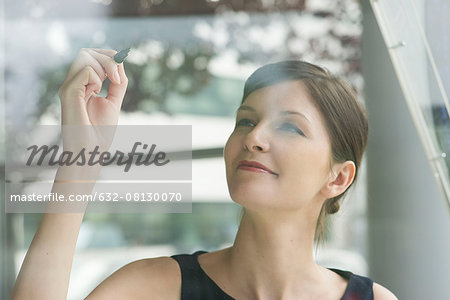 Woman preparing to write on window with marker