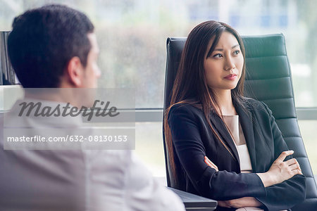 Business woman with arms folded looking away with air of disappointment