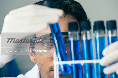 Researcher scrutinizing test tubes in laboratory