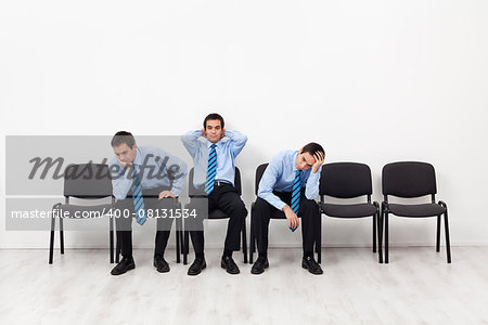 Desperate businessmen sitting on chairs having doubts about the future